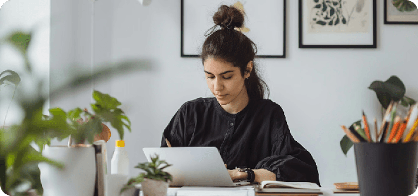 Person working focused on a laptop in a bright workspace